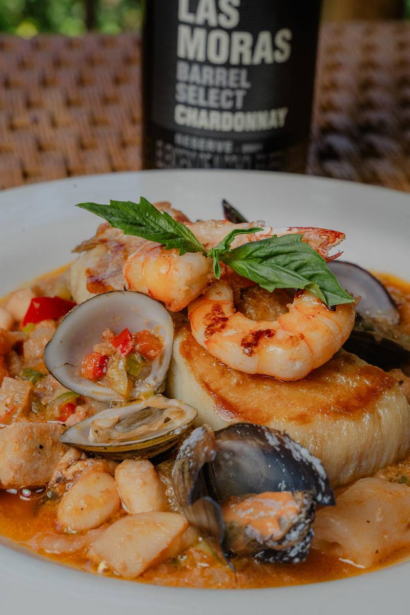 Plato de mariscos con camarones, almejas y mejillones junto a una botella de Chardonnay